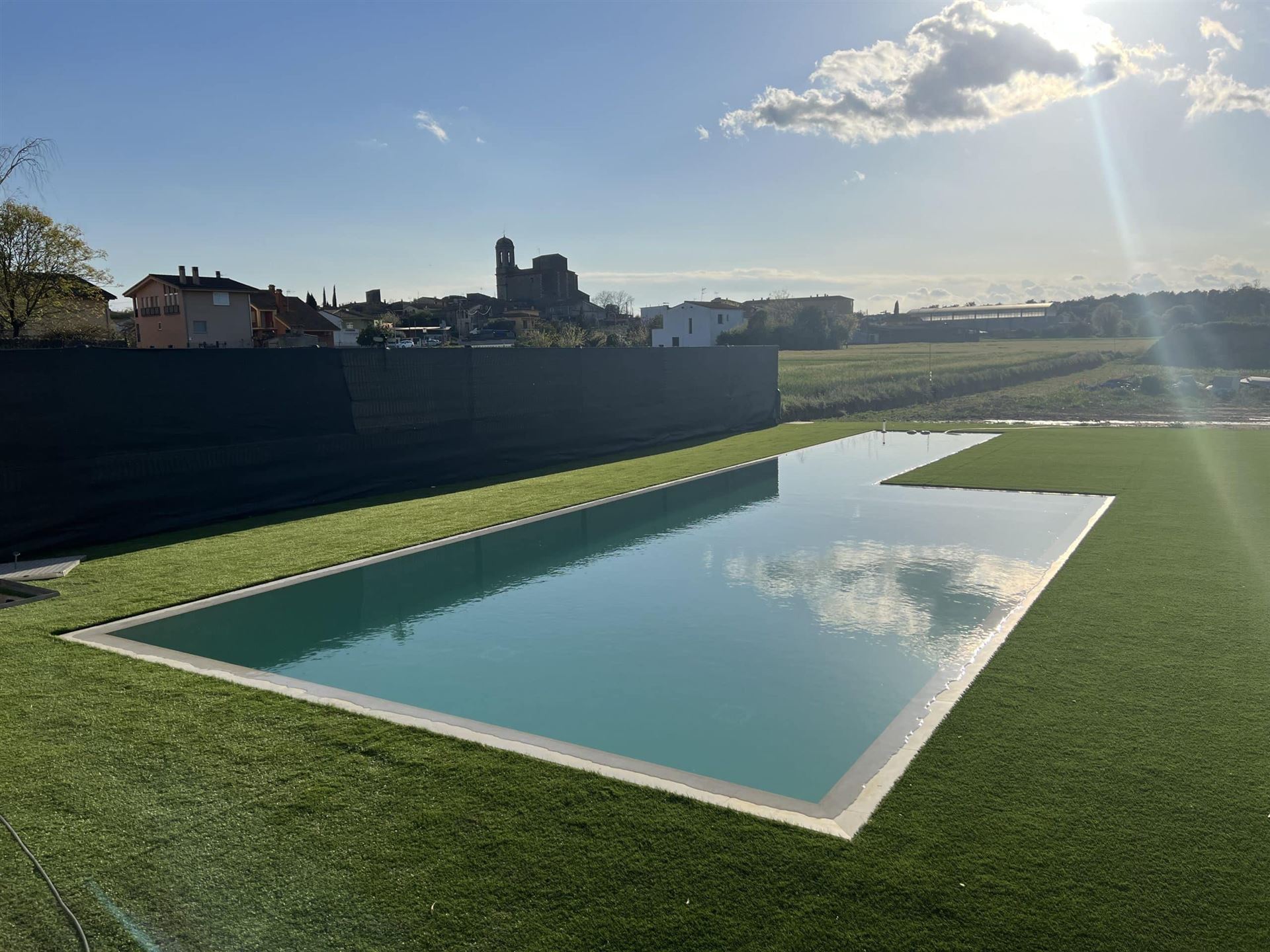 Piscina de bordes blancos en un jardín